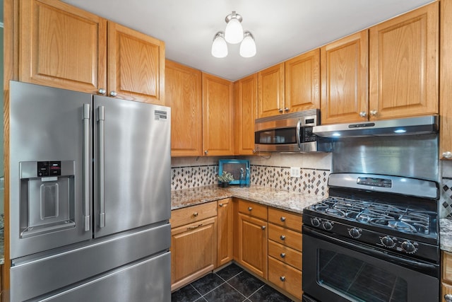 6636 Lancaster Ln N, Maple Grove, MN 55369 - kitchen with appliances with stainless steel finishes, dark tile patterned flooring, under cabinet range hood, light stone counters, and tasteful backsplash