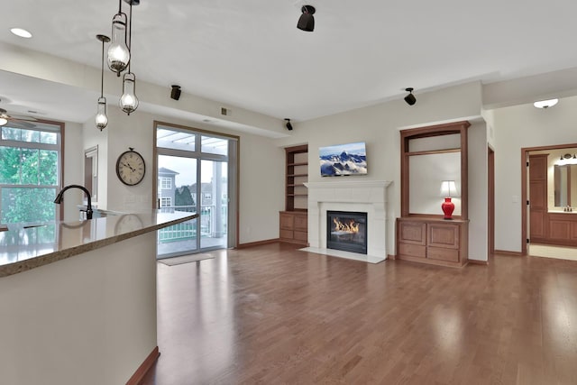 17417 72nd Ave N Unit 205, Maple Grove, MN 55311 - unfurnished living room featuring ceiling fan, a fireplace with flush hearth, and wood finished floors
