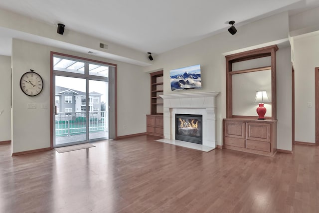 17417 72nd Ave N Unit 205, Maple Grove, MN 55311 - unfurnished living room featuring wood finished floors, a fireplace with flush hearth, and built in features
