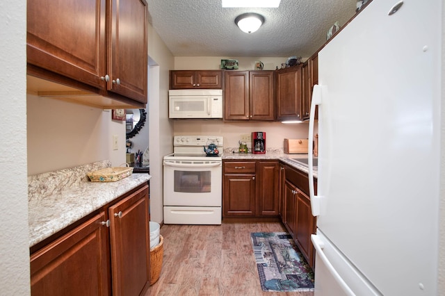 1415 Lake St Unit 114, Alexandria, MN 56308 - kitchen featuring white appliances, light wood-style floors, and a textured ceiling