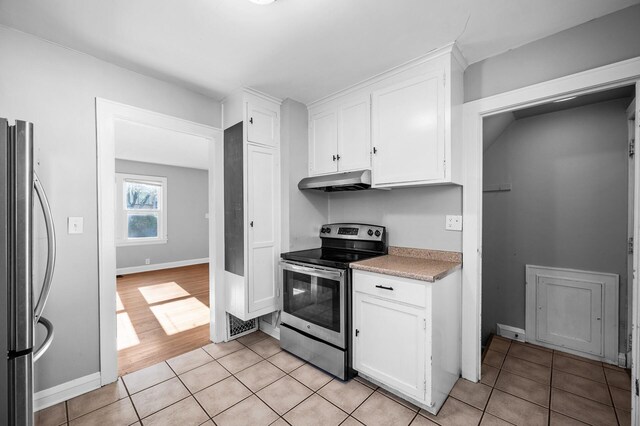3806 Jackson St NE, Columbia Heights, MN 55421 - kitchen with stainless steel appliances, white cabinetry, light tile patterned floors, under cabinet range hood, and light countertops