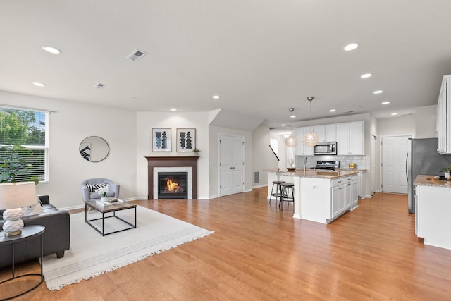 732 Wildflower Ln, Chanhassen, MN 55317 - living area featuring recessed lighting, light wood-type flooring, and a tiled fireplace