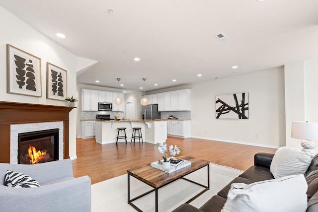732 Wildflower Ln, Chanhassen, MN 55317 - living room with light wood finished floors, recessed lighting, and a warm lit fireplace