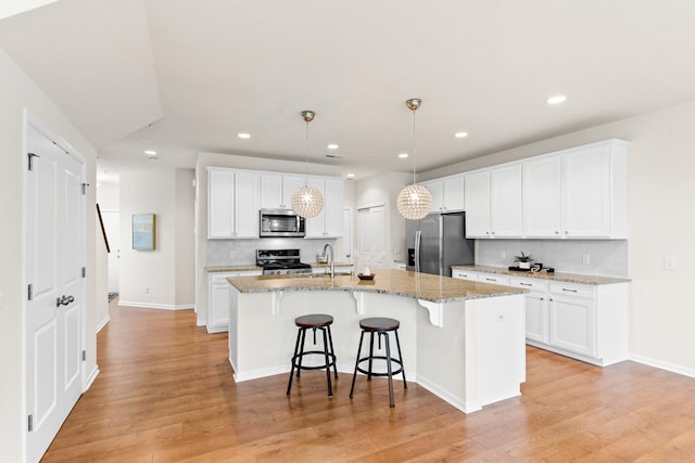732 Wildflower Ln, Chanhassen, MN 55317 - kitchen with appliances with stainless steel finishes, backsplash, white cabinetry, a breakfast bar area, and recessed lighting