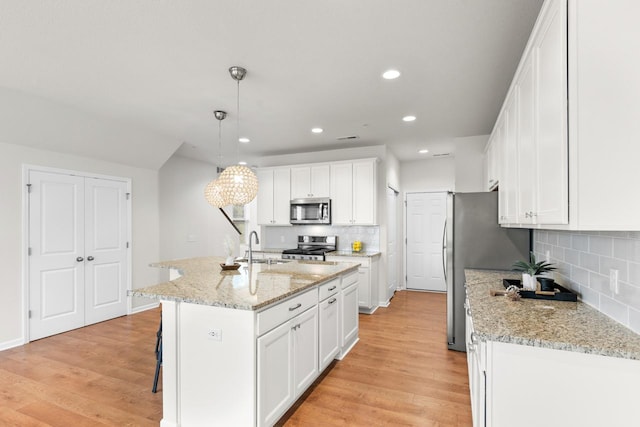 732 Wildflower Ln, Chanhassen, MN 55317 - kitchen featuring stainless steel appliances, decorative backsplash, recessed lighting, light wood finished floors, and white cabinetry