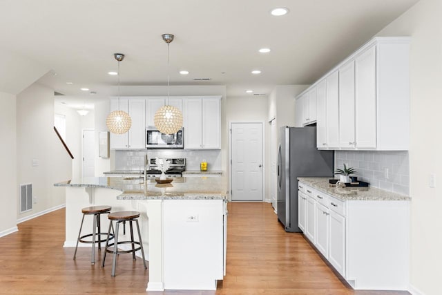732 Wildflower Ln, Chanhassen, MN 55317 - kitchen featuring appliances with stainless steel finishes, tasteful backsplash, white cabinetry, and recessed lighting