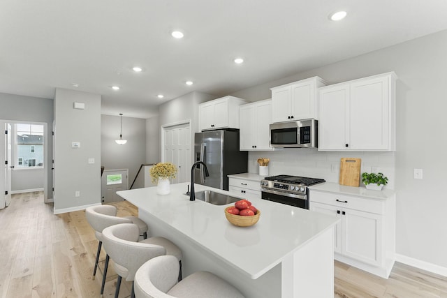 2720 Kepler Ave NE, Saint Michael, MN 55376 - kitchen featuring stainless steel appliances, an island with sink, backsplash, a breakfast bar area, and recessed lighting