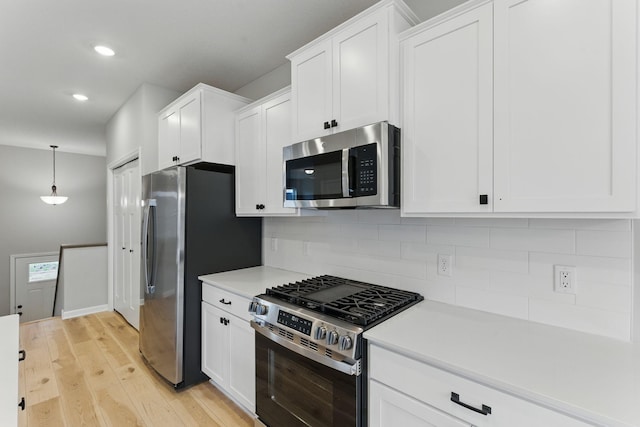 2720 Kepler Ave NE, Saint Michael, MN 55376 - kitchen with stainless steel appliances, decorative backsplash, white cabinets, light countertops, and light wood-style flooring