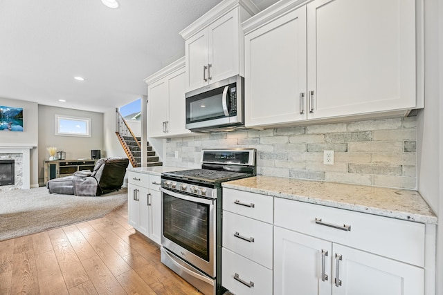 19550 Albany Cir NW, Elk River, MN 55330 - kitchen featuring stainless steel appliances, open floor plan, white cabinets, backsplash, and recessed lighting