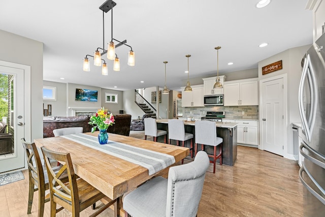 19550 Albany Cir NW, Elk River, MN 55330 - dining room with stairway, light wood-style floors, and recessed lighting