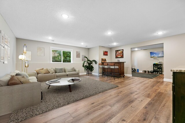 19550 Albany Cir NW, Elk River, MN 55330 - living area featuring a dry bar, wood finished floors, recessed lighting, and a textured ceiling