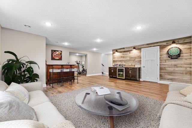 19550 Albany Cir NW, Elk River, MN 55330 - living area with beverage cooler, a dry bar, light wood-style floors, wooden walls, and recessed lighting