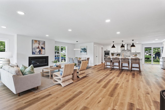 6901 Dawson Ln, Edina, MN 55435 - living area with recessed lighting, a glass covered fireplace, and light wood-type flooring