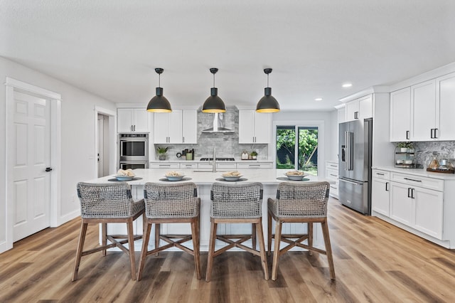 6901 Dawson Ln, Edina, MN 55435 - kitchen featuring appliances with stainless steel finishes, light countertops, backsplash, light wood finished floors, and a kitchen bar