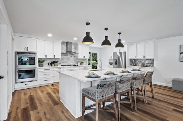 6901 Dawson Ln, Edina, MN 55435 - kitchen with wall chimney range hood, stainless steel appliances, tasteful backsplash, wood finished floors, and recessed lighting