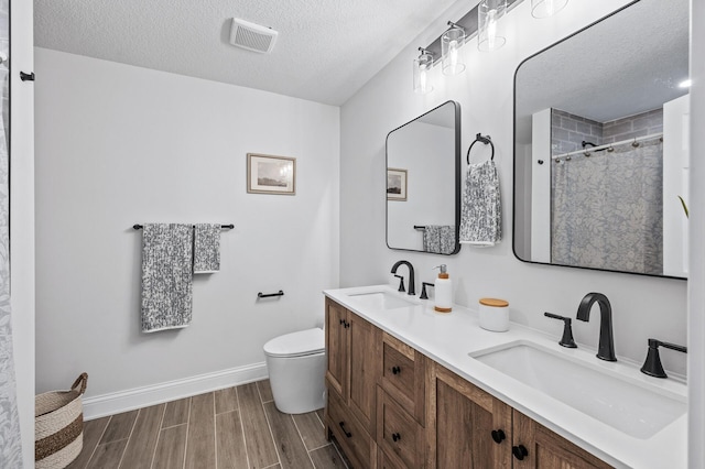 6901 Dawson Ln, Edina, MN 55435 - bathroom with double vanity, a textured ceiling, wood finish floors, and a shower with shower curtain