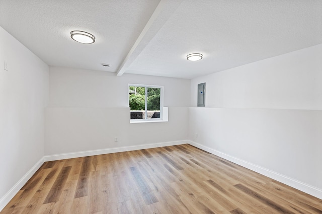 6901 Dawson Ln, Edina, MN 55435 - unfurnished room featuring electric panel, light wood-style floors, a textured ceiling, and beam ceiling