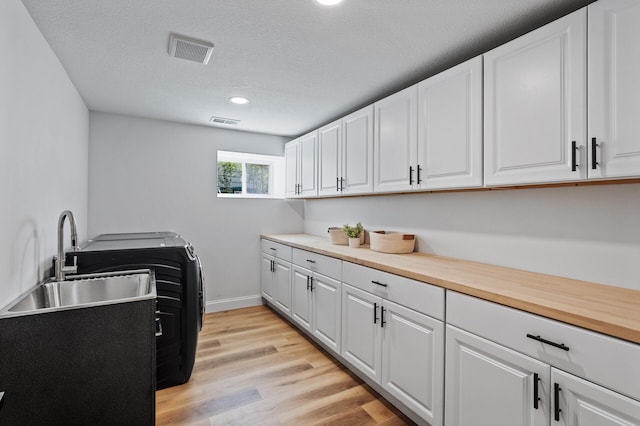 6901 Dawson Ln, Edina, MN 55435 - washroom with cabinet space, light wood-type flooring, recessed lighting, and a textured ceiling