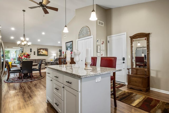 722 Hilltop Dr, Taylors Falls, MN 55084 - kitchen featuring high vaulted ceiling, a ceiling fan, a breakfast bar, white cabinets, and open floor plan