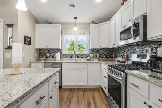 722 Hilltop Dr, Taylors Falls, MN 55084 - kitchen with stainless steel appliances, white cabinetry, backsplash, and dark wood-style floors