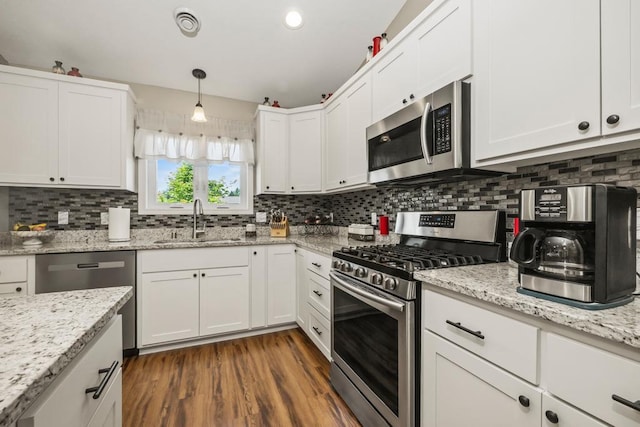 722 Hilltop Dr, Taylors Falls, MN 55084 - kitchen with stainless steel appliances, white cabinetry, and tasteful backsplash
