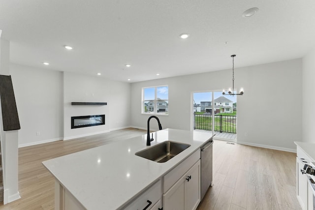 2726 Kepler Ave NE, Saint Michael, MN 55376 - kitchen with light wood-style floors, a glass covered fireplace, stainless steel dishwasher, hanging light fixtures, and recessed lighting