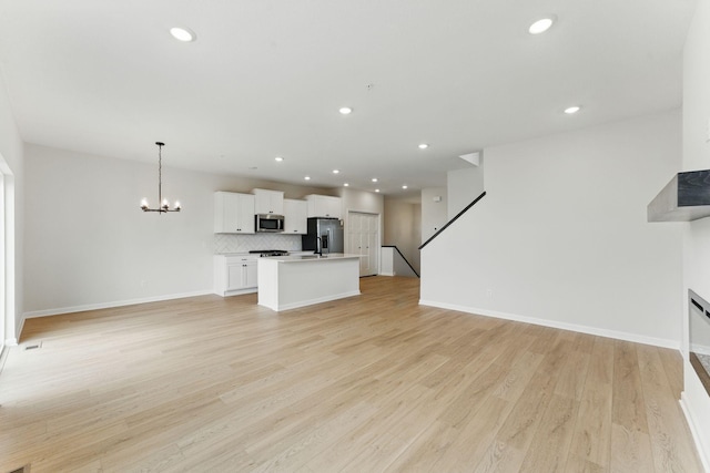2726 Kepler Ave NE, Saint Michael, MN 55376 - unfurnished living room featuring a chandelier, light wood finished floors, recessed lighting, and stairs