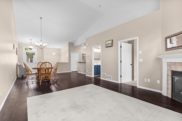 1437 131st Dr NE, Blaine, MN 55449 - dining room featuring dark wood-type flooring, a tiled fireplace, high vaulted ceiling, and a chandelier