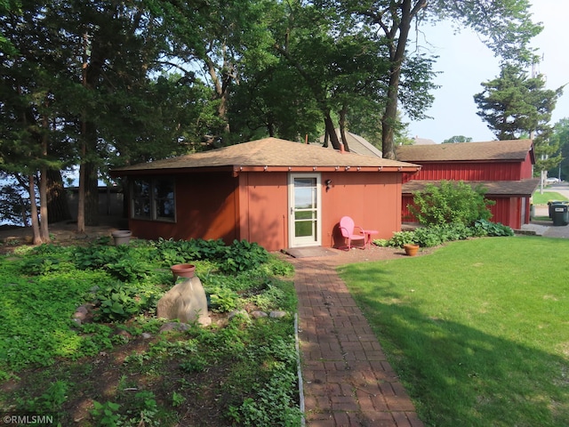 9429 Jeske Ave NW, Corinna Twp, MN 55302 - back of property featuring an outdoor structure, a lawn, and a shingled roof