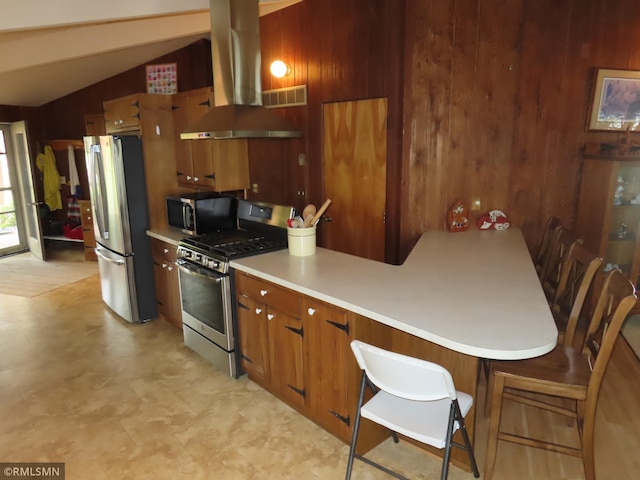 9429 Jeske Ave NW, Corinna Twp, MN 55302 - kitchen featuring stainless steel appliances, wood walls, brown cabinetry, light countertops, and light floors
