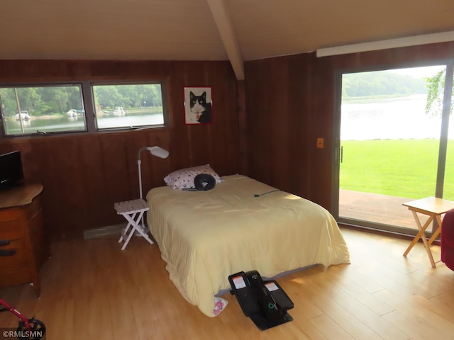 9429 Jeske Ave NW, Corinna Twp, MN 55302 - bedroom featuring access to exterior, beamed ceiling, light wood-style floors, and wood walls