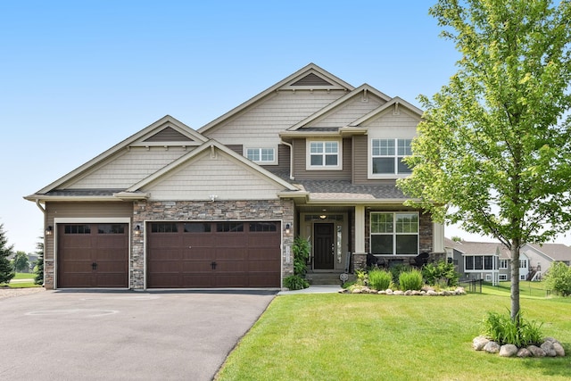 14675 77th St NE, Otsego, MN 55330 - craftsman-style home with a front lawn, driveway, an attached garage, and stone siding