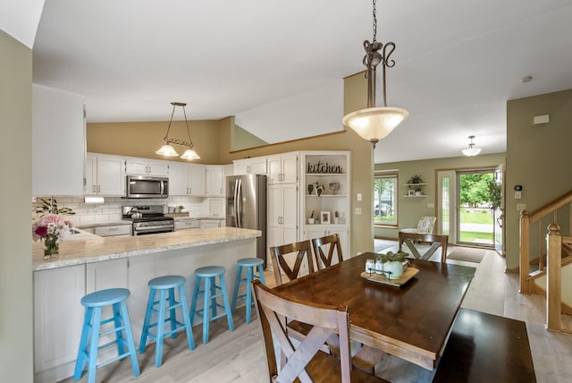 5278 River Wood Dr, Savage, MN 55378 - dining room with vaulted ceiling, light wood-style flooring, and stairway