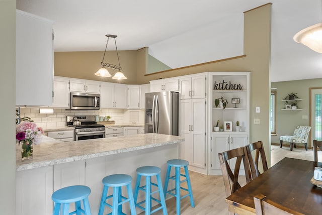 5278 River Wood Dr, Savage, MN 55378 - kitchen with appliances with stainless steel finishes, light countertops, a peninsula, light wood-type flooring, and backsplash