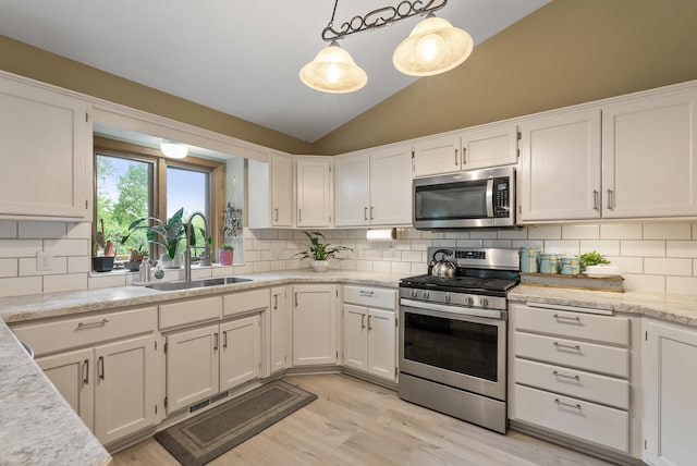 5278 River Wood Dr, Savage, MN 55378 - kitchen with stainless steel appliances, light wood finished floors, lofted ceiling, white cabinets, and light countertops