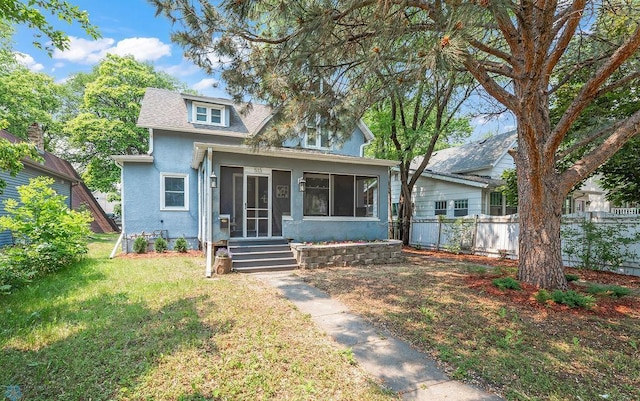 513 10th St S, Fargo, ND 58103 - bungalow featuring stucco siding, a sunroom, and roof with shingles