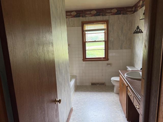 103 Circle Dr, Jackson, MN 56143 - bathroom with vanity, shower / washtub combination, and tile walls