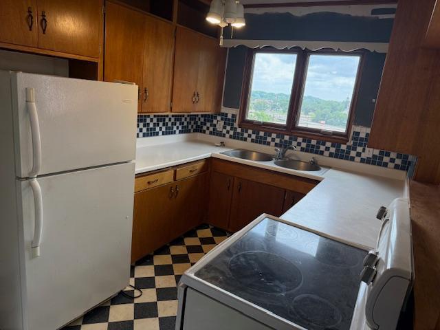103 Circle Dr, Jackson, MN 56143 - kitchen with freestanding refrigerator, light flooring, range, light countertops, and decorative backsplash