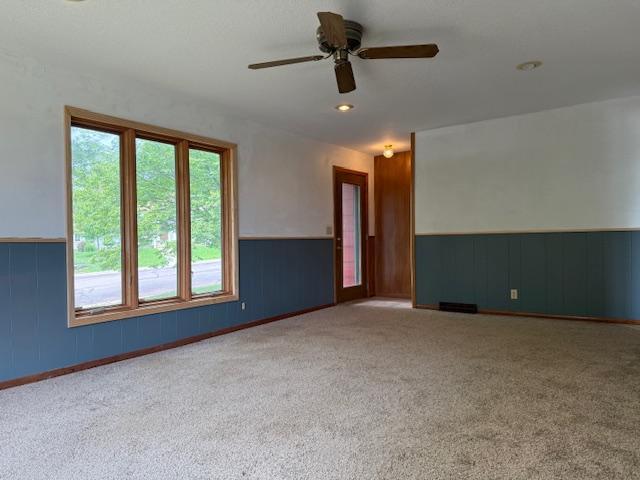 103 Circle Dr, Jackson, MN 56143 - carpeted empty room with wainscoting and a ceiling fan