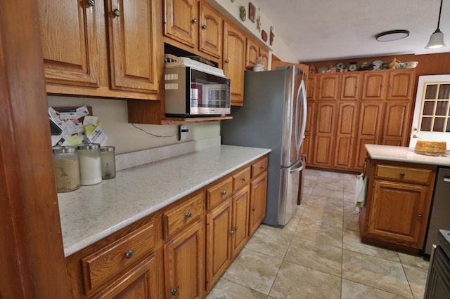 1138 Wintergreen Ln NE, Bemidji, MN 56601 - kitchen with stainless steel appliances, brown cabinets, pendant lighting, and light stone counters