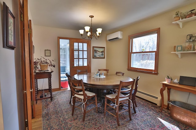 1138 Wintergreen Ln NE, Bemidji, MN 56601 - dining area with a wall unit AC, a chandelier, wood finished floors, and a baseboard radiator