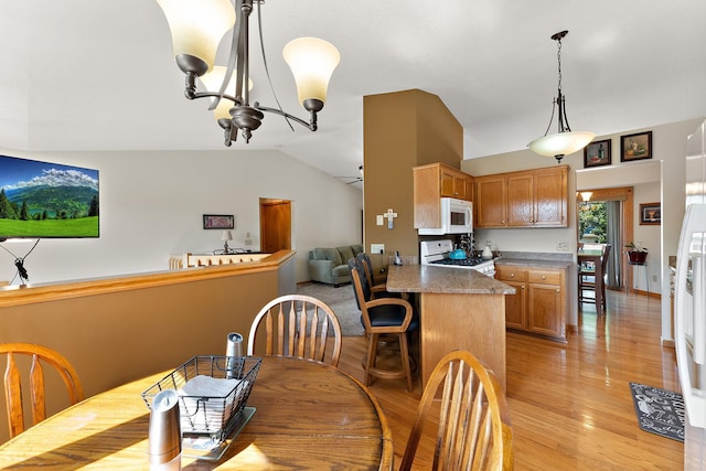 17317 Faraday Ct, Lakeville, MN 55024 - dining room with lofted ceiling, a chandelier, and light wood-style flooring