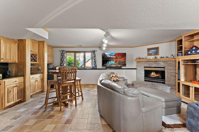 17317 Faraday Ct, Lakeville, MN 55024 - living area featuring stone tile floors, a textured ceiling, and a fireplace