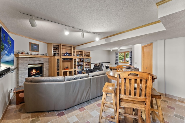 17317 Faraday Ct, Lakeville, MN 55024 - living area with rail lighting, a textured ceiling, a brick fireplace, stone tile floors, and ornamental molding