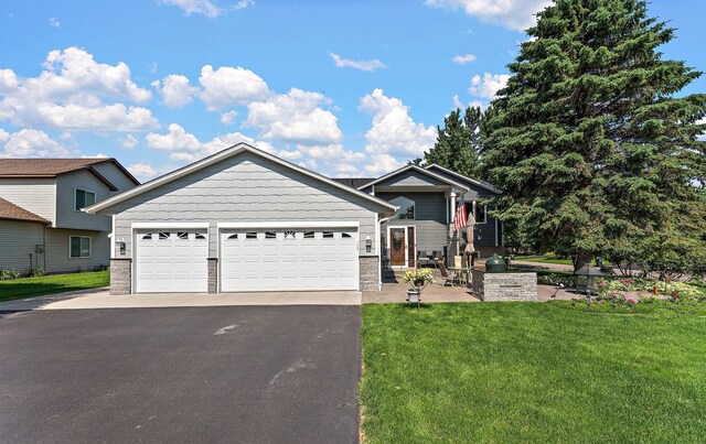 17317 Faraday Ct, Lakeville, MN 55024 - view of front facade featuring driveway, a front lawn, a garage, and stone siding