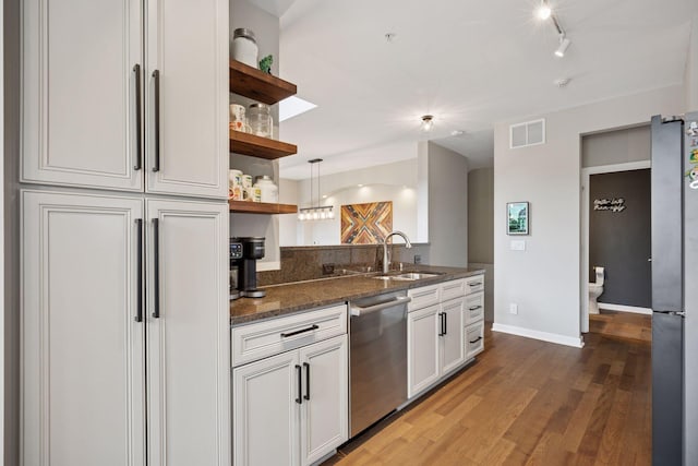 1020 Portland Ave, Minneapolis, MN 55404 - kitchen with stainless steel appliances, open shelves, wood finished floors, dark stone counters, and white cabinets