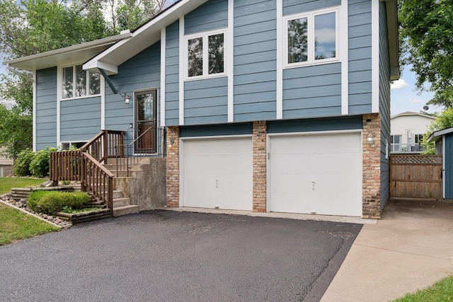 1650 107th Ave NW, Coon Rapids, MN 55433 - bi-level home featuring asphalt driveway and an attached garage