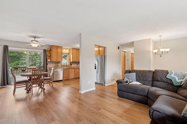 1650 107th Ave NW, Coon Rapids, MN 55433 - living area featuring light wood finished floors, a chandelier, and ceiling fan