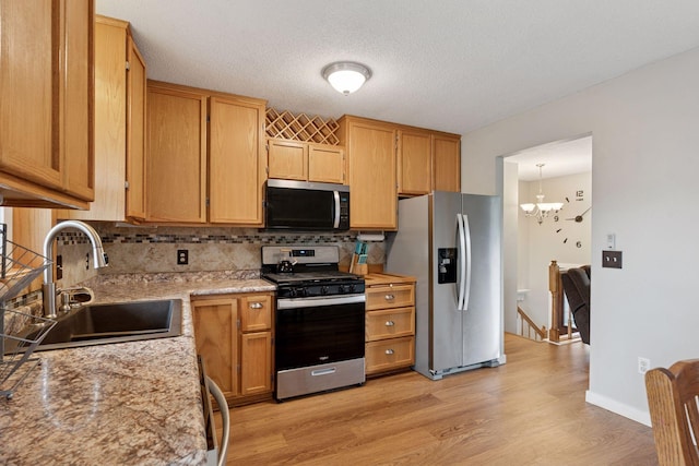 1650 107th Ave NW, Coon Rapids, MN 55433 - kitchen featuring stainless steel appliances, backsplash, light wood finished floors, a chandelier, and light stone countertops