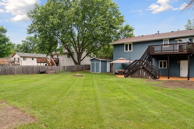 1650 107th Ave NW, Coon Rapids, MN 55433 - fenced backyard featuring stairs, a wooden deck, a storage unit, and a fire pit